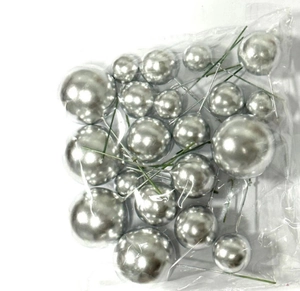 Detailed view of silver foam decorative cake balls in various sizes with green wire stems