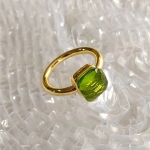 Detailed close-up of a gold square ring set with an emerald-green zircon stone