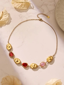 Detail of 18k gold plated stainless steel necklace with red and pink glass stones