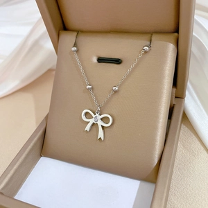 Silver bowknot pendant necklace with zircon gemstone in a beige jewelry gift box