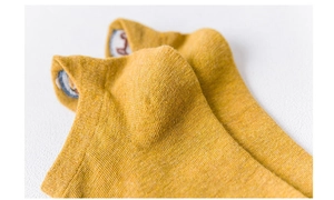 Detail of yellow knit short sock showing fine breathable fabric texture and stitching