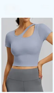 Dettaglio del crop top blu-grigio con scollatura asimmetrica e tessuto sportivo a maglia