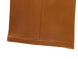 Detail shot of caramel brown satin wide-leg pants showing premium stitching and fabric