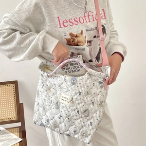 Détail d'un sac à main matelassé à rayures bleues avec bandoulière rose réglable