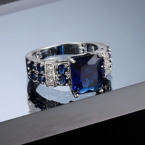 Macro shot of square blue zircon ring with detailed pave setting and silver plating