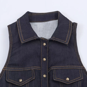 Front detail of slim fit dark blue denim jumpsuit with metal buttons and flap pockets