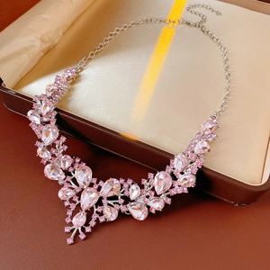 Detail view of pink crystal drop pendant necklace with zircon floral accents in jewelry box