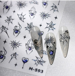 Macro view of M-593 nail stickers featuring black spider, web designs and purple accents