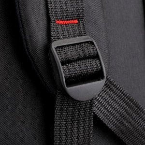 Detail of adjustable shoulder strap with red reinforced stitching on black travel backpack