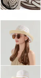 Detail of striped straw sun hat featuring adjustable inner cord and woven bow ornament