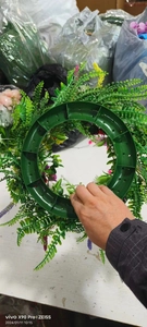 Detail view showing the sturdy green plastic base structure of the artificial wildflower wreath