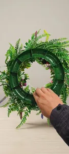 Detail view showing the sturdy green plastic base structure of the artificial wildflower wreath