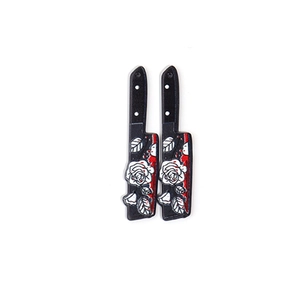Detail of acrylic Halloween knife pendants with white rose pattern and red blood splatters