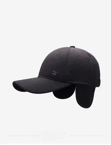 Detail view of winter black wool baseball cap featuring fold-down earflaps and metal logo