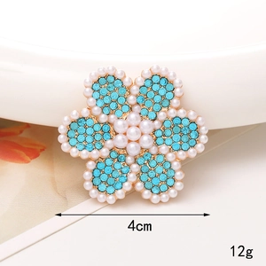 Détail macro d'une broche tournesol en cristal bleu de 4cm avec perles et or