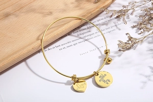 Detail of adjustable gold heart bracelet with Love and mi mama engraved charms