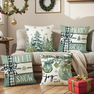 Set of 4 Christmas pillow covers with green pine trees and festive holiday slogans on a sofa