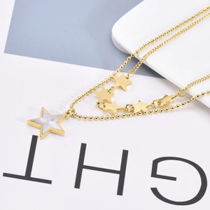 Detail view of 18K gold double layer necklace with white shell star pendant