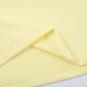 Detail der gleichmäßigen Doppelnaht am Saum des hellgelben Strickkleidstoffs