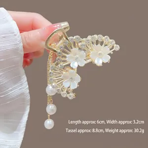 Vue détaillée de la pince à cheveux lotus blanc avec glands en perles et dimensions