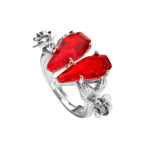 Macro shot of silver ring with red coffin stones and rose flower carvings