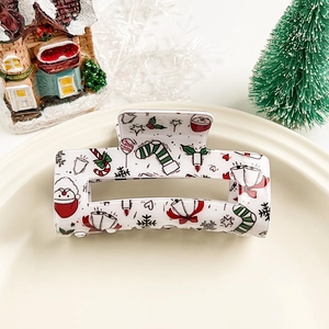 Vue détaillée d'une pince à cheveux de Noël blanche avec des motifs festifs et du Père Noël
