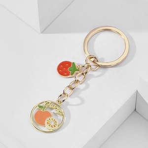 Creative fruit keychain with golden metal ring and orange and strawberry pendants
