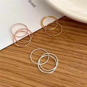 Detailed view of 925 silver stacked rings in gold, silver, and rose gold finishes