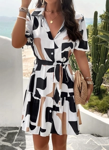 Detail of short sleeve dress with geometric print and waist tie in beach resort setting