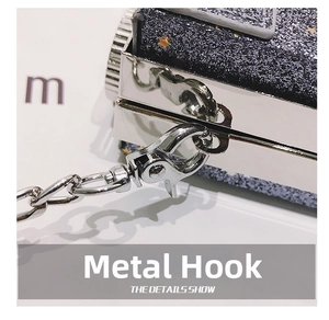 Macro detail of silver lobster clasp and metal chain on sequined camera box bag
