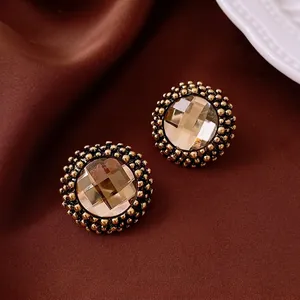 Vintage champagne gemstone stud earrings with gold bead trim on velvet fabric