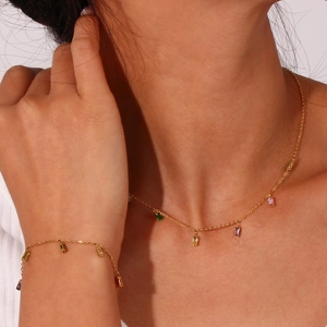 Detail of gold necklace and bracelet set with colorful rectangular cubic zirconia