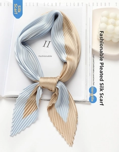Detail of light blue and champagne gold pleated scarf on a fashion magazine