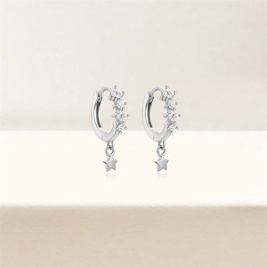 Detailed view of S925 sterling silver hoop earrings with pavé stones and star pendants