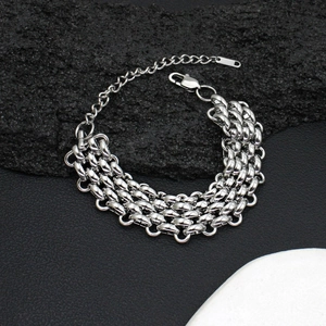 Detail of wide chunky stainless steel link bracelet with lobster clasp on volcanic stone