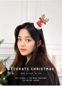 Détail d'une pince à cheveux bonnet de Noël rouge avec bois dorés et bordure en fourrure