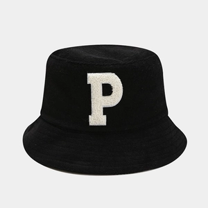 Vue détaillée d'un bob noir avec la lettre P brodée en tissu éponge blanc texturé