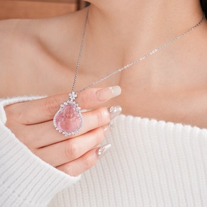Macro detail of the pink resin Buddha pendant with sparkling zircon floral accents