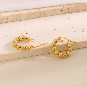 Dettaglio ravvicinato degli orecchini a cerchio con perline placcati oro 18K