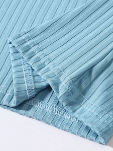 Détail du tricot côtelé bleu montrant les coutures doubles de qualité sur l'ourlet