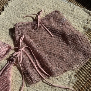 Detailed texture of pink mesh cover-up with stylish tie waist and mesh pattern