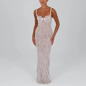 Detailed close-up of white lace maxi dress with backless design and golden chain belt