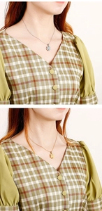 Detailed close-up of hollow four-leaf clover necklaces in gold and silver finishes