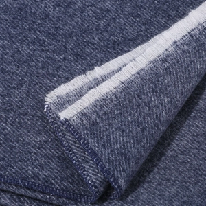 Macro view of blue brushed fabric detail with soft texture and white fringe tassels