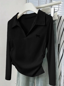 Nahaufnahme eines schwarzen Langarm-Poloshirts mit Schleifendetail und seitlichem Kordelzug