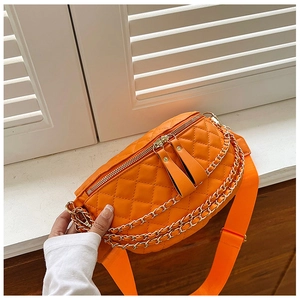 Detail of bright orange quilted chest bag with double metal chains and wide strap