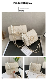 Detail view of white quilted crossbody bag featuring elegant pearl handle and gold chain strap