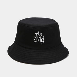 Detail of white be Kind embroidery and heart on a black canvas bucket hat with stitching