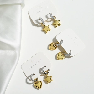 Asymmetric gold star and moon zircon hoop earrings set on elegant white silk background