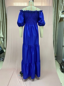 Close-up of smocked bodice and tiered skirt detail on a blue off-shoulder dress